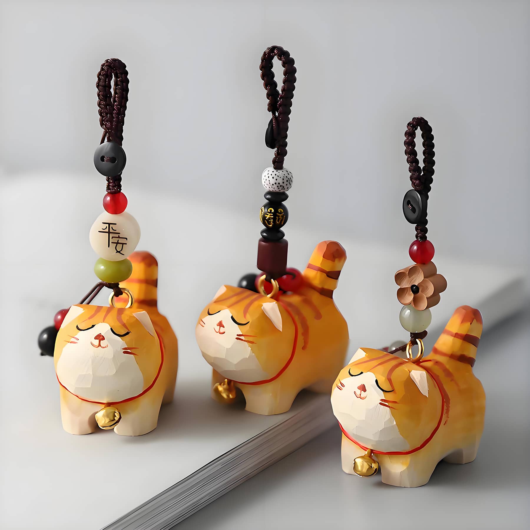 3 orange cat charms stand on a book